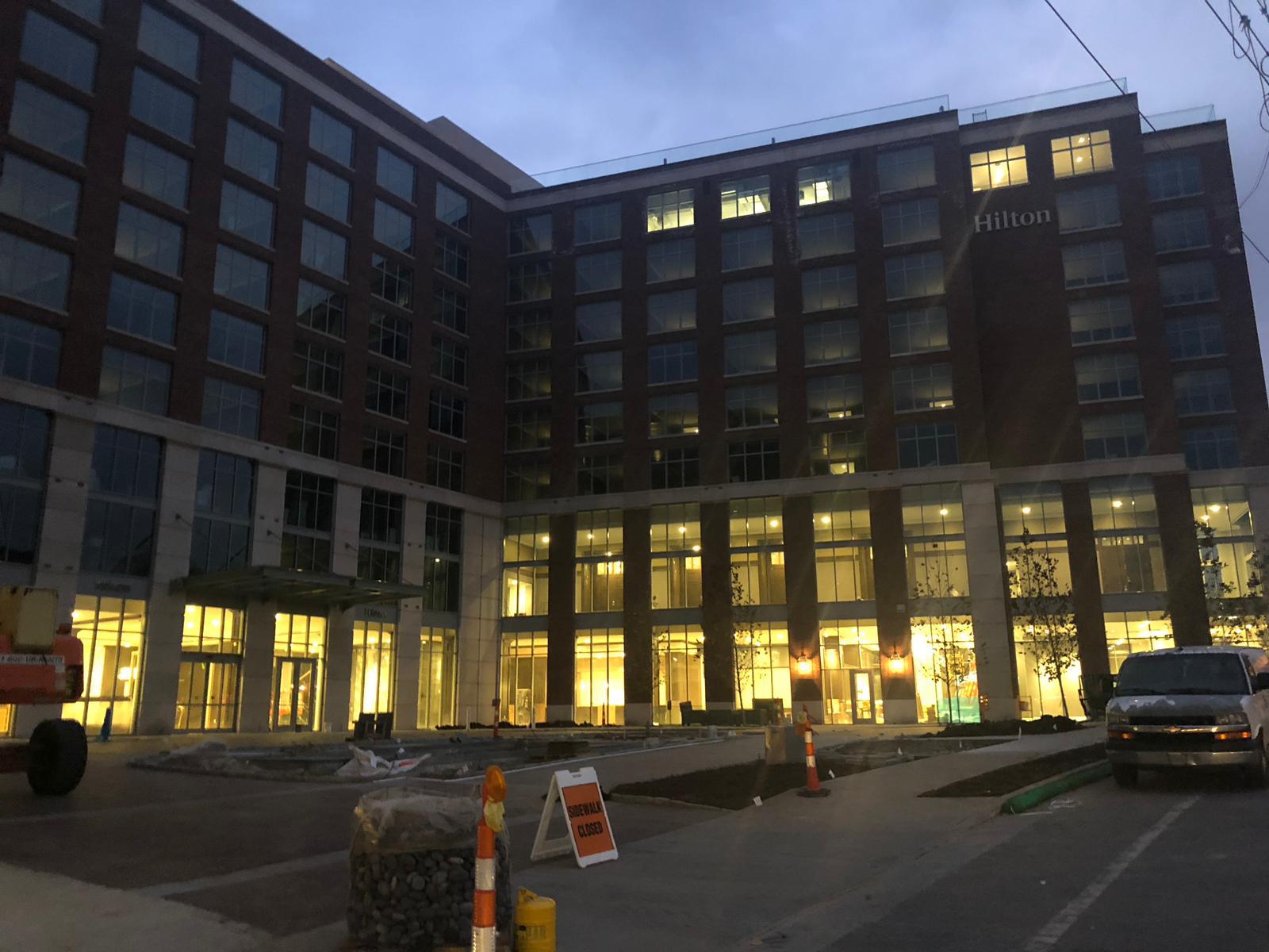Hilton hotel exterior at dusk with illuminated windows