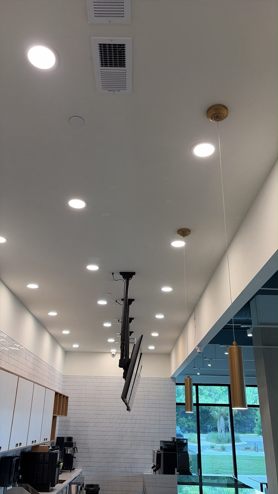 Rows of recessed lights above a retail counter and seating area